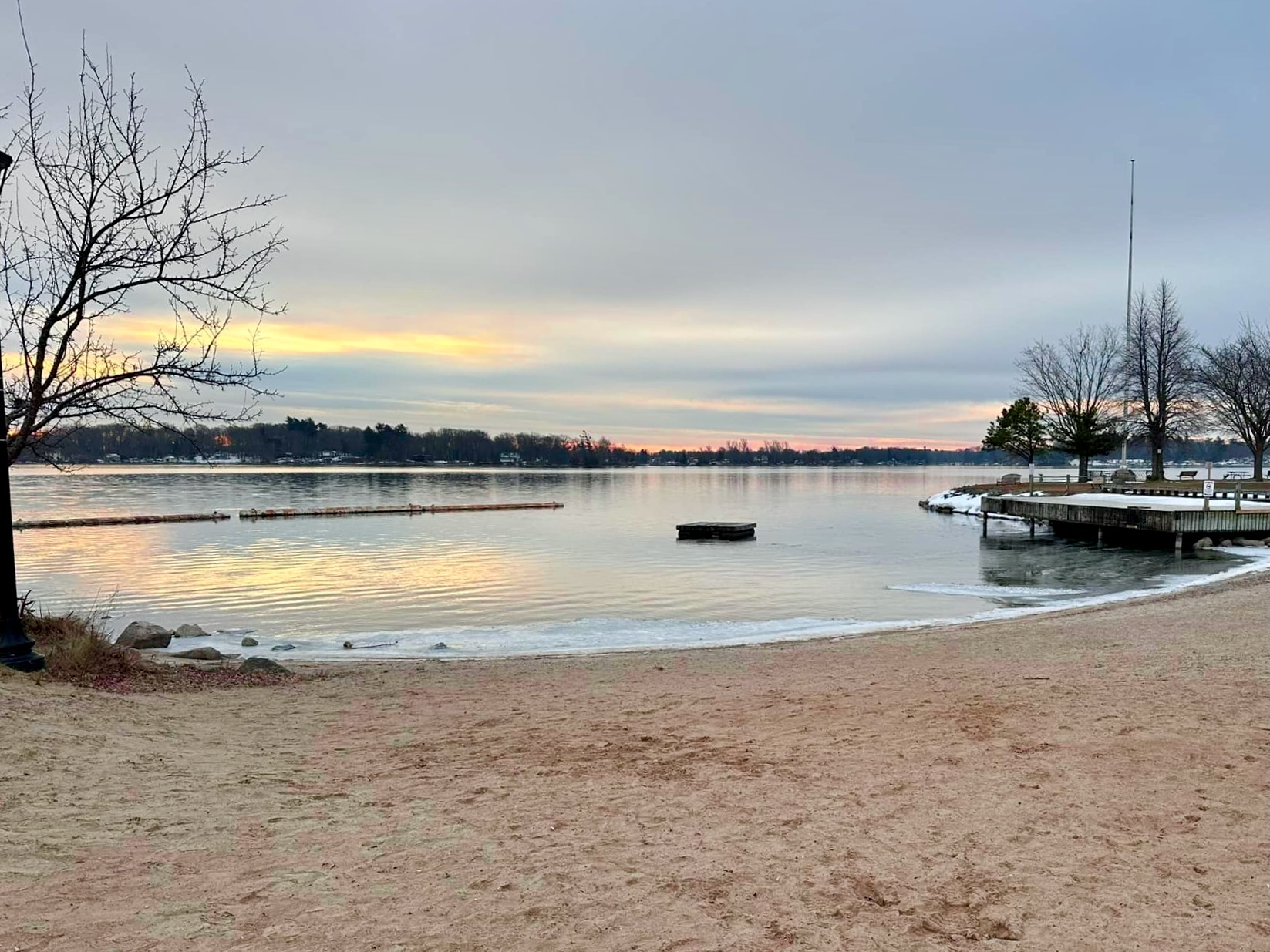 beach and water with bits of snow and ice at the shoreline